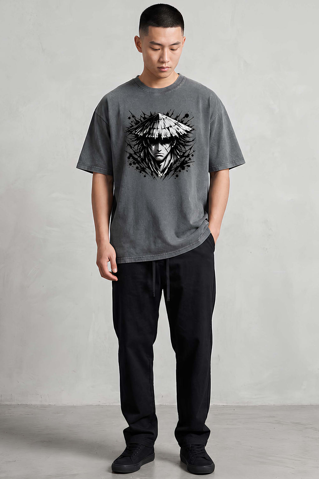 Man wearing a gray t-shirt with a graphic design on a plain background