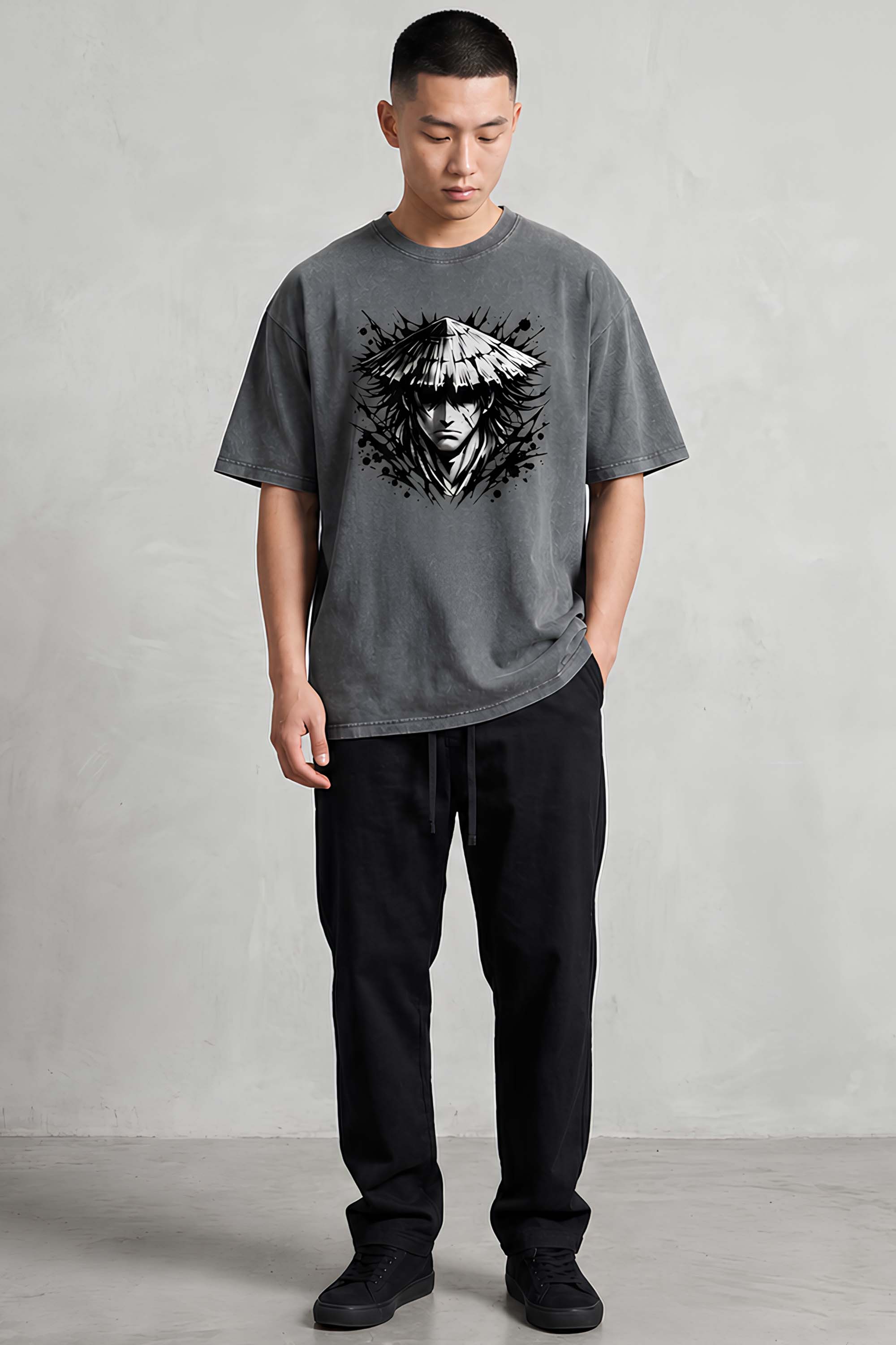 Man wearing a gray t-shirt with a graphic design on a plain background
