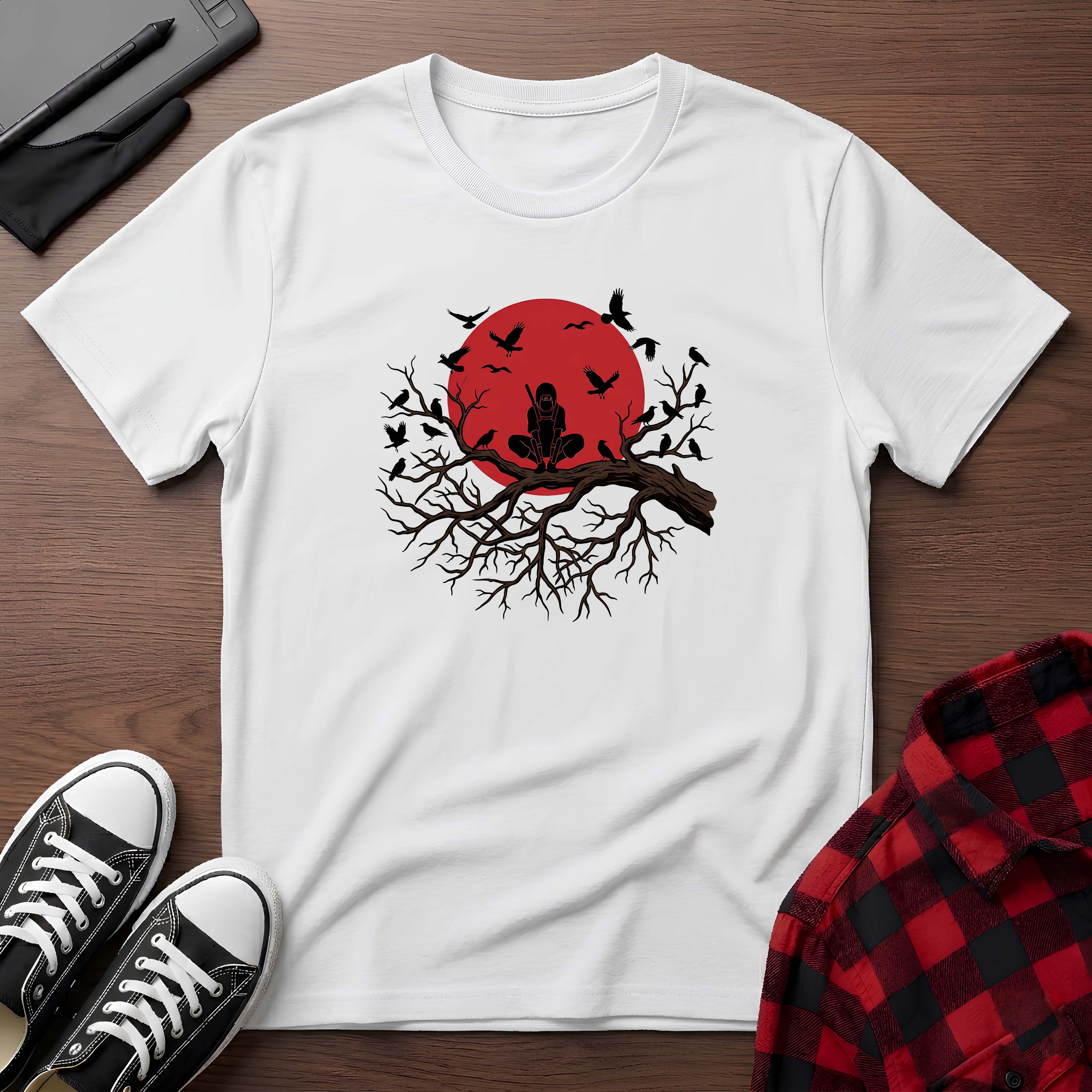 White t-shirt with a red sun and black tree design on a wooden surface with shoes and a plaid shirt.